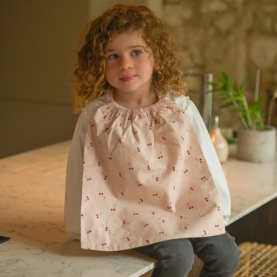 Serviette élastiquée avec motifs cerises rouges sur fond rose pastel